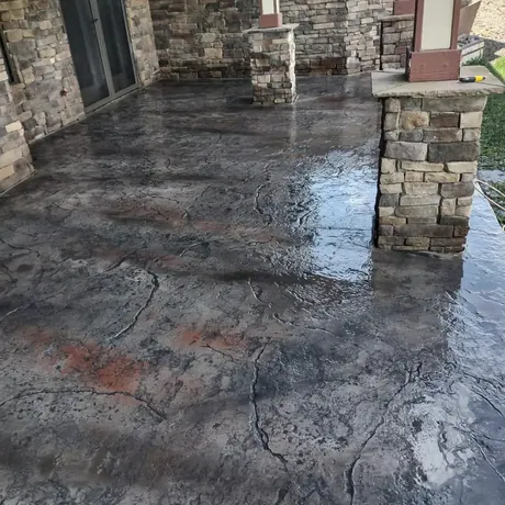 Flagstone stamped concrete patio floor with irregular stone shapes in mixed earth tones.